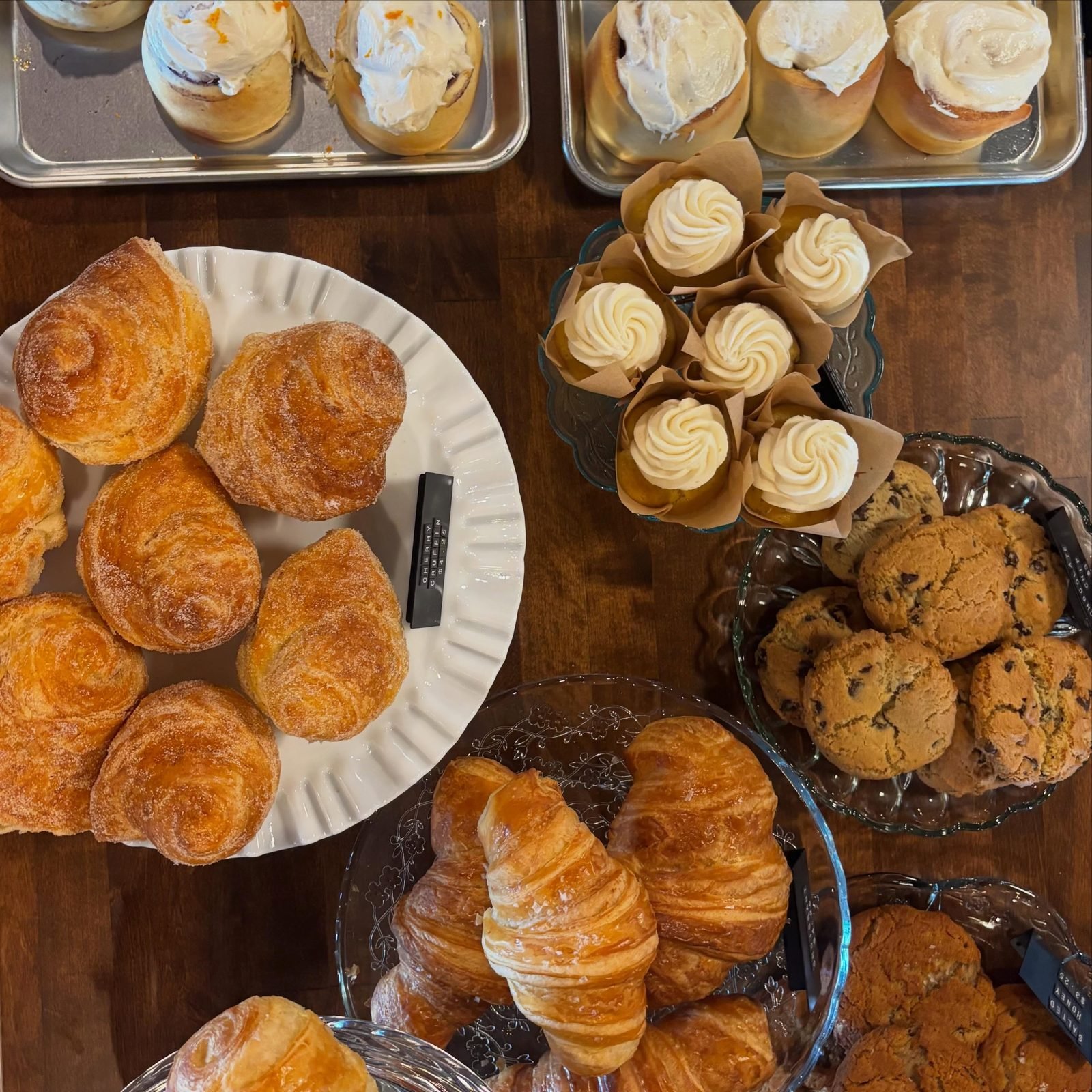 A spread of fresh cruffins, cinnamon rolls, croissants and cookies